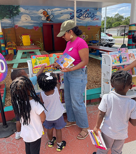 Sonia shows books to young children at event