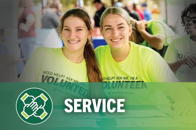 Two female students with volunteer shirts, words at bottom service