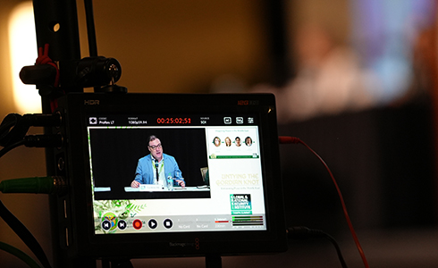 An AV monitor showing the recording of a panel discussion at Tampa Summit 4