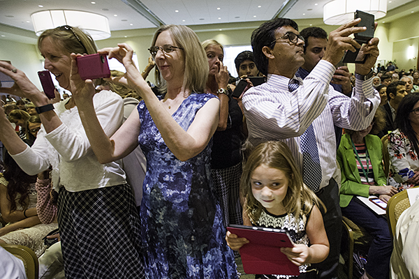 Friends and family taking photos at a ceremony in 2015