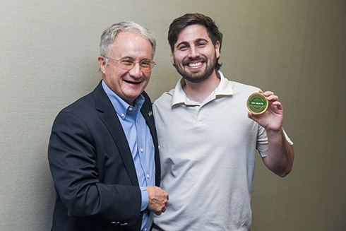Dr. Charles Lockwood presents Ryan Rossy with a USF Health Culture Coin.