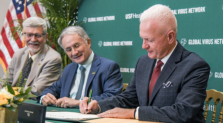 Three smiling men, left-right, Sten Vermund, MD, PhD, Charles Lockwood, MD, and Brett Giroir, MD, sign an agreement. 