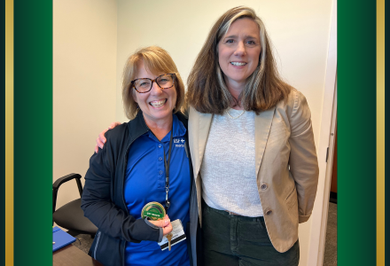 Patti Lane and Renée Dubault posing together with culture coin. 