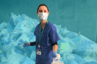 Erika Kimball in scrubs holding trash