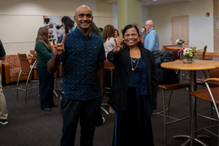 Dr. Pon with her son holding up the "go bulls" sign in the college of nursing