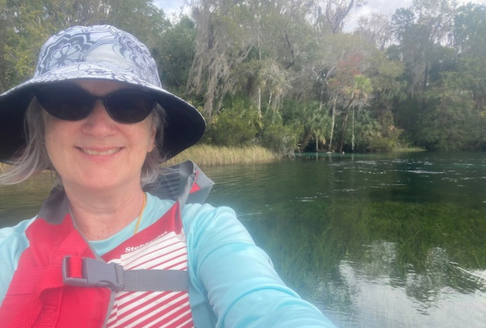 woman with hat and sunglasses on a river