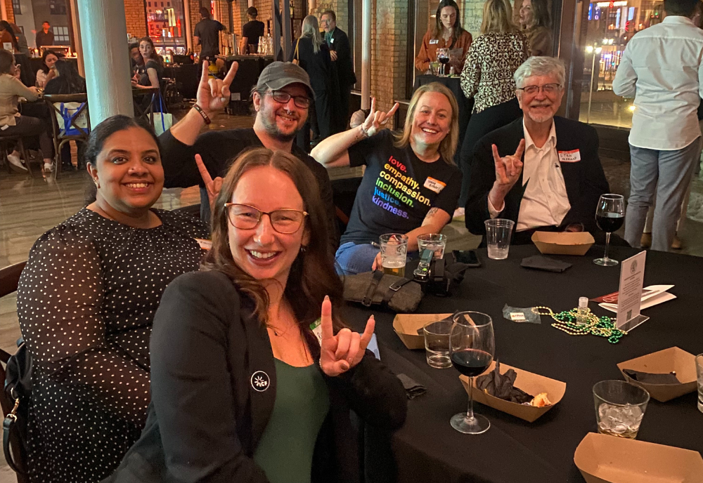 five people doing the USF bull hand sign