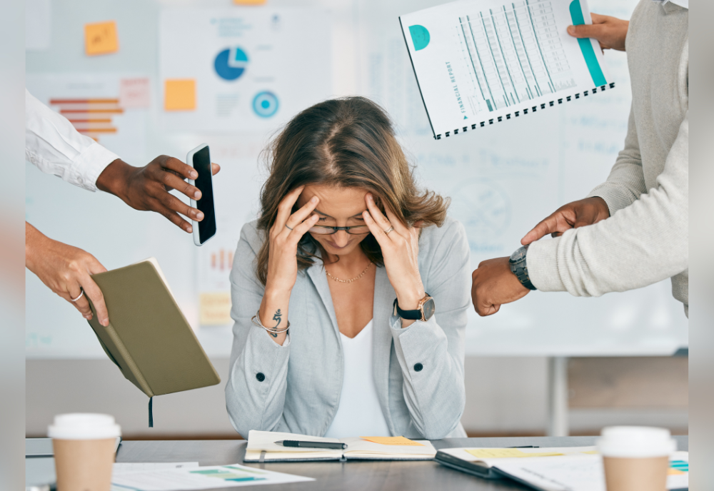 a person with her head in her hands at their work desk