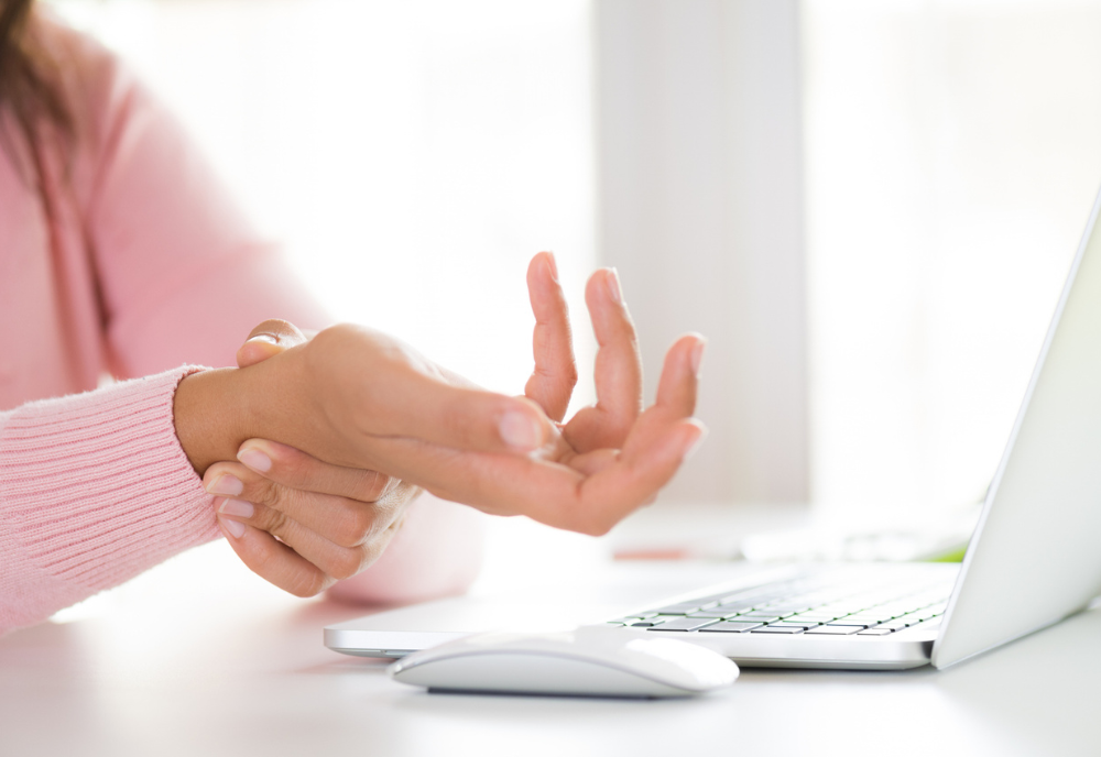 Closeup woman holding her wrist pain from using computer. Office syndrome hand pain by occupational disease.