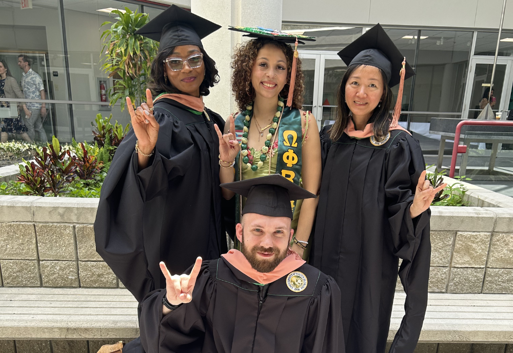 4 graduates in cap and gown