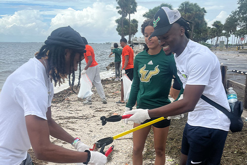 students picking up after Hurricane Helene