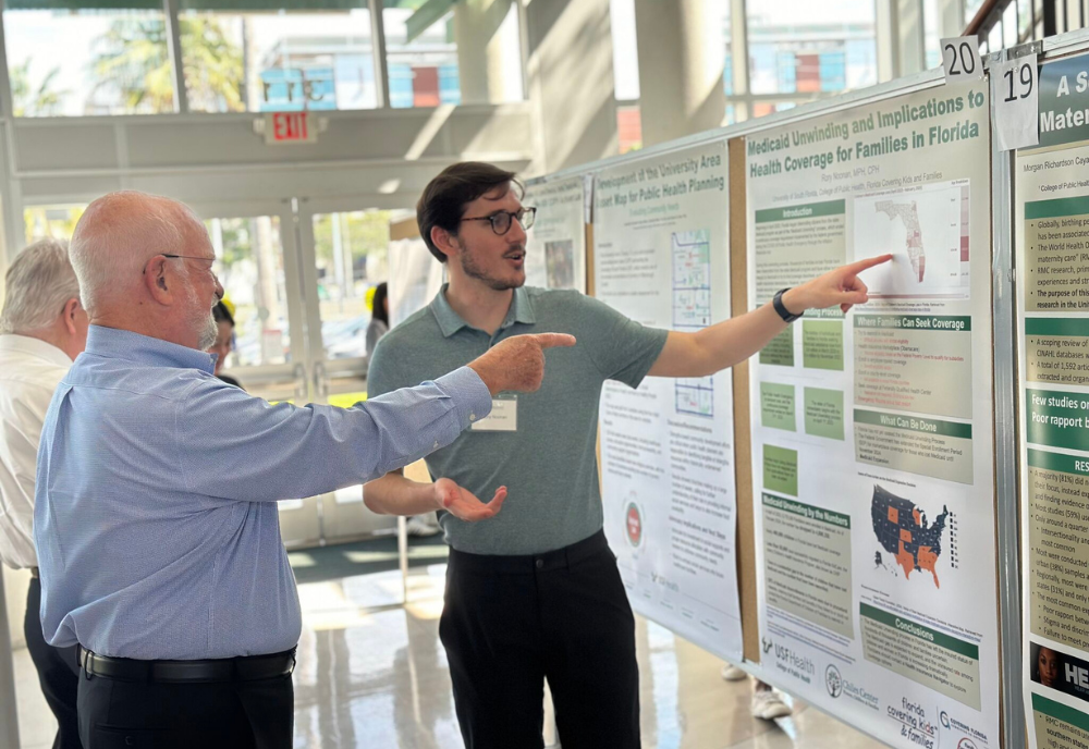 two men pointing at poster