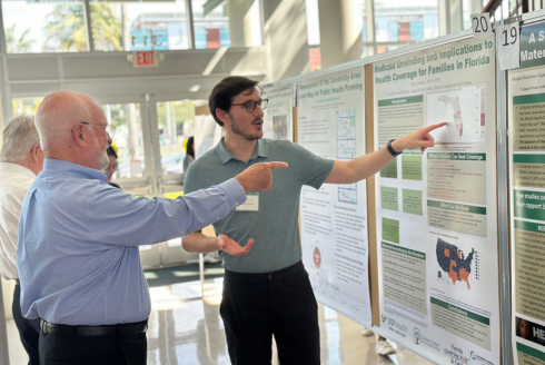 two men pointing at poster