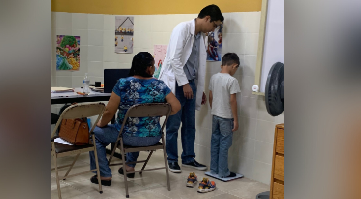 a kid being weighed in a medical setting