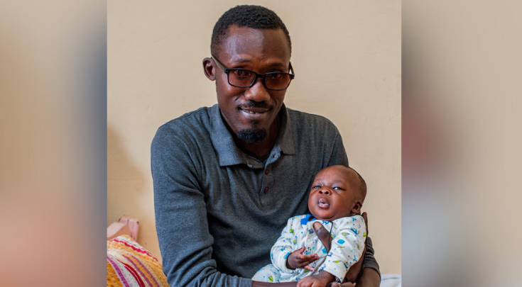 a father holding an infant