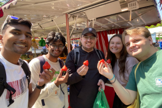 Chad Hosein and students on the Germany Innovation and engineering trip smil while holding strawberries