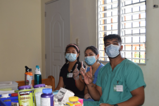 Akaash Vijeesh and other students smile in the clinic