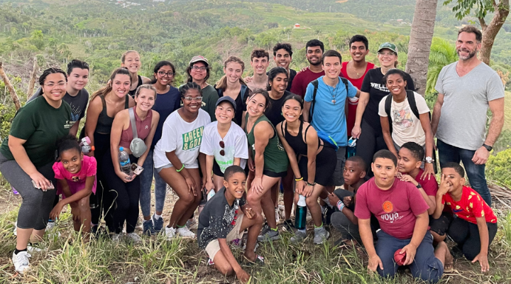 Students smile on a peak overlooking the hillside