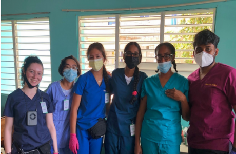 Honors students smile while wearing medical equipment in the Dominican Republic. 