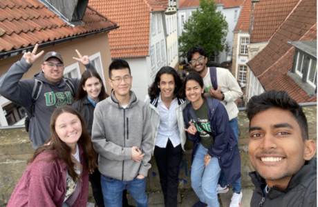 Germany innovation in engineering students smile in front of picturesque rooftops. 