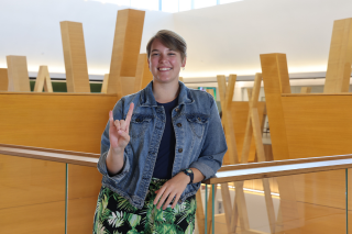 USF St. Petersburg Judy Genshaft Honors College alum Gabby Schwager poses while making a Go Bulls hand sign.