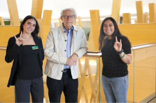 Former Scottish First Minister and USF Honors professor Henry McLeish poses with the Honor Roll Podcast hosts Fabiana Requena and Reva Gandhi in the Judy Genshaft Honors College