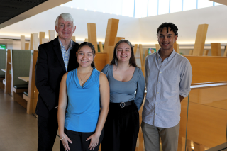 USF Provost Emeritus Ralph Wilcox and Wilcox Scholars Vanessa Quiroz, Sandra Napolitano, and Nico Lavaud pose in the Judy Genshaft Honors College building.