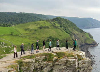 Nine USF students stand in a line as they gaze over an English cliffside near Exeter in the United Kingdom