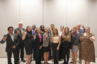 Judy Genshaft Honors College faculty and Wilcox Scholars Members pose while making "Go Bulls" signs.