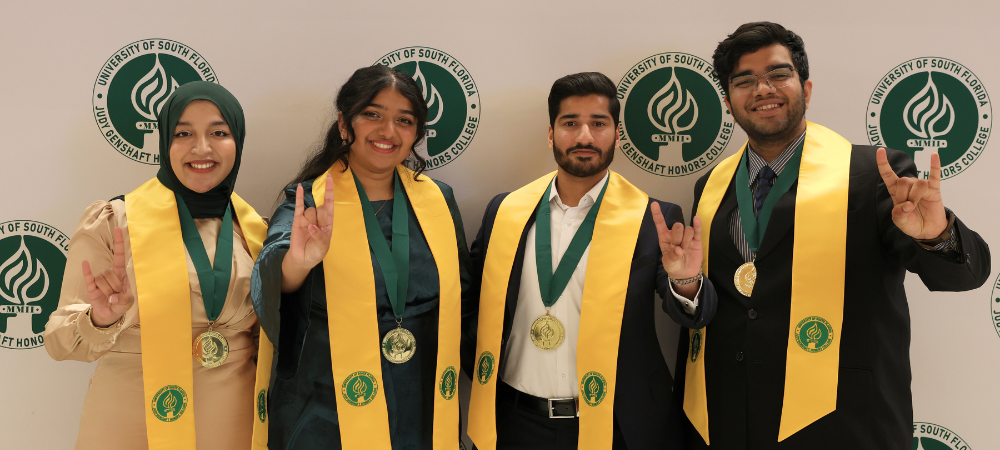 Dean's Circle of Merit recipients in stoles posing after Tampa Graduation ceremony