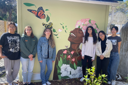 Honors students smile next to the completed breath of life mural.