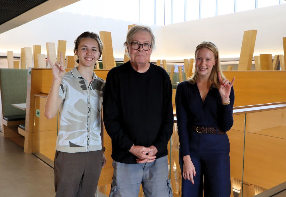 Daniel Ruth and students Anna Gustafson and Grady Vickers smile and pose in the Honors atrium.