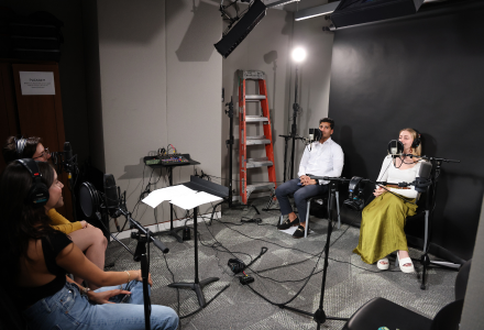 Judy Genshaft Honors College student leaders Abdul Muqeet Khawaja and Taylor Herman sit in a studio space as they record an episode of the Honor Roll Podcast in the Judy Genshaft Honors College