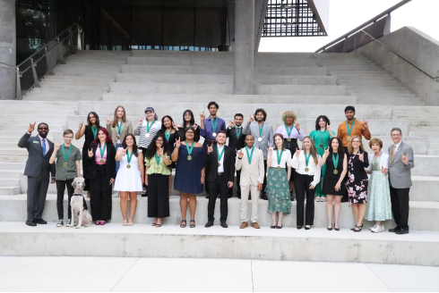 Honors College Spring 2024 Graduates smile for a group photo with Dr. Judy Genshaft and Steven Greenbaum. 