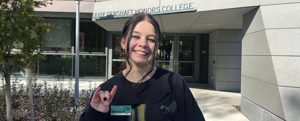 Honors student Katelynn Paciorek smiles infront of the Judy Genshaft Honors College 