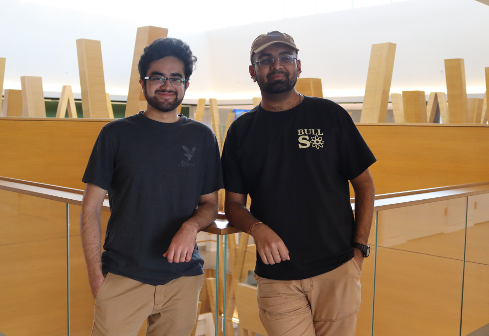 Tehami Ammad and Lalith Roopesh smile in the Judy Genshaft Honors College building