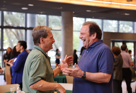 USF Honors Dean Emeritus Dr. Stuart Silverman laughs with a guest at the dedication of the Silverman Walkway at the Judy Genshaft Honors College