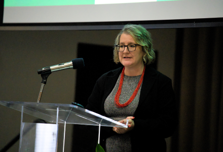 Dr. Cayla Lanier stands at a lecturn at the 2024 Honors Symposium