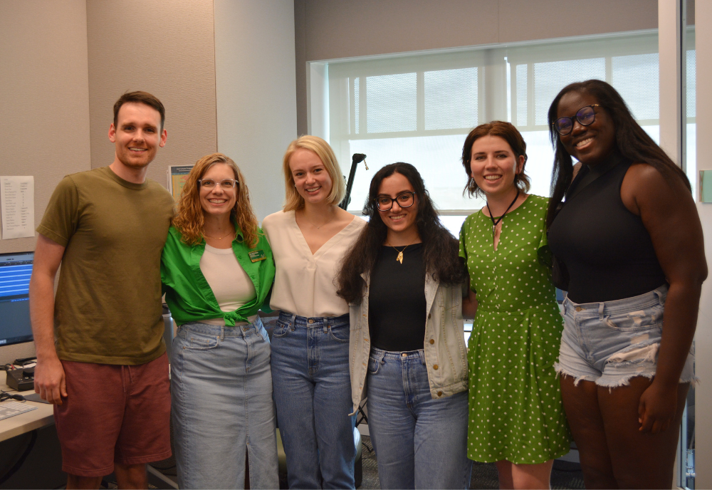 Honors alumni Dr. Ife Bolujo, Dr. Trent Lippert, Dr. Karina Bowers, and Dr. Sarah Awshah smile with Dr. Lindy Davidson and the student host in the AV studio. 