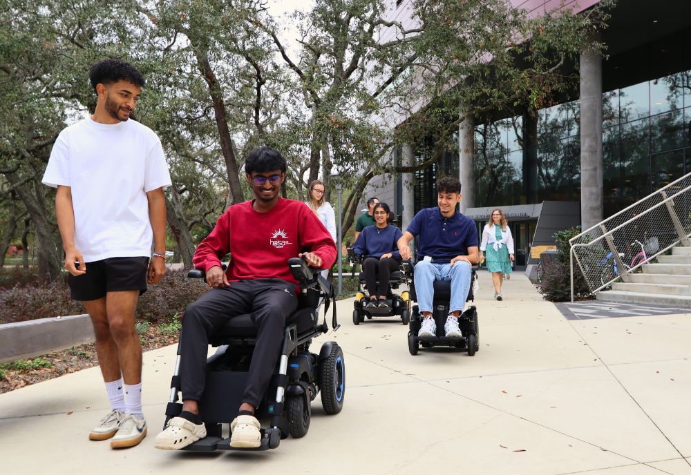 Students from Romano's course try out mobility equipment outside the JGHC building