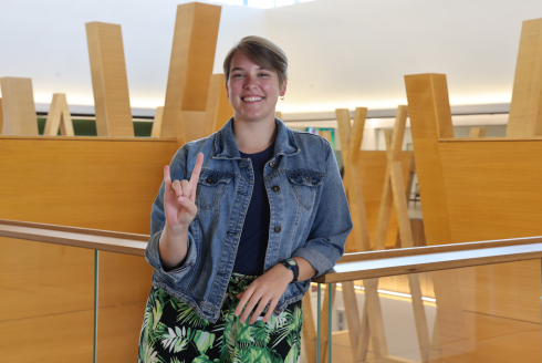 USF St. Petersburg Judy Genshaft Honors College alum Gabby Schwager poses while making a Go Bulls hand sign.