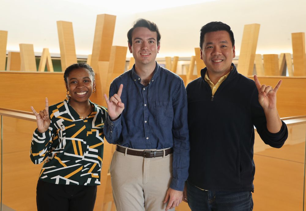 Anrae Stephenson-Frazier, Martin Ladjimi, and Dr. Kevin Lee pose in the Honors atrium, holding up the Go Bulls hand sign