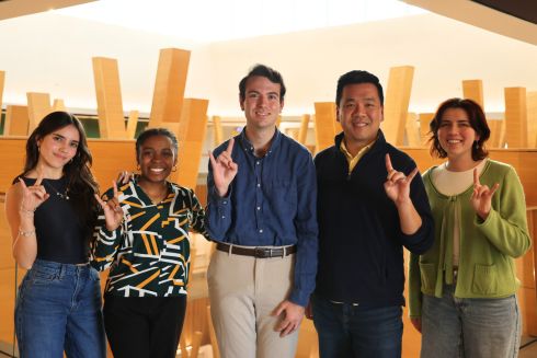 Fabiana Requena, Anrae Stephenson-Frazier, Martin Ladjimi, Dr. Kevin Lee, and Caroline Merriman pose in the Honors atrium with the Go Bulls hand sign