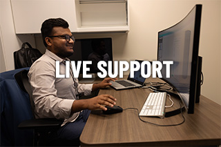 A man sits smiling at a computer with the words live support over the image