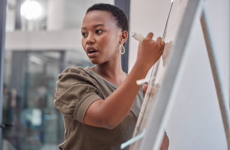 woman writing on white board