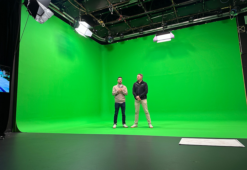 2 men stand in a green screen studio