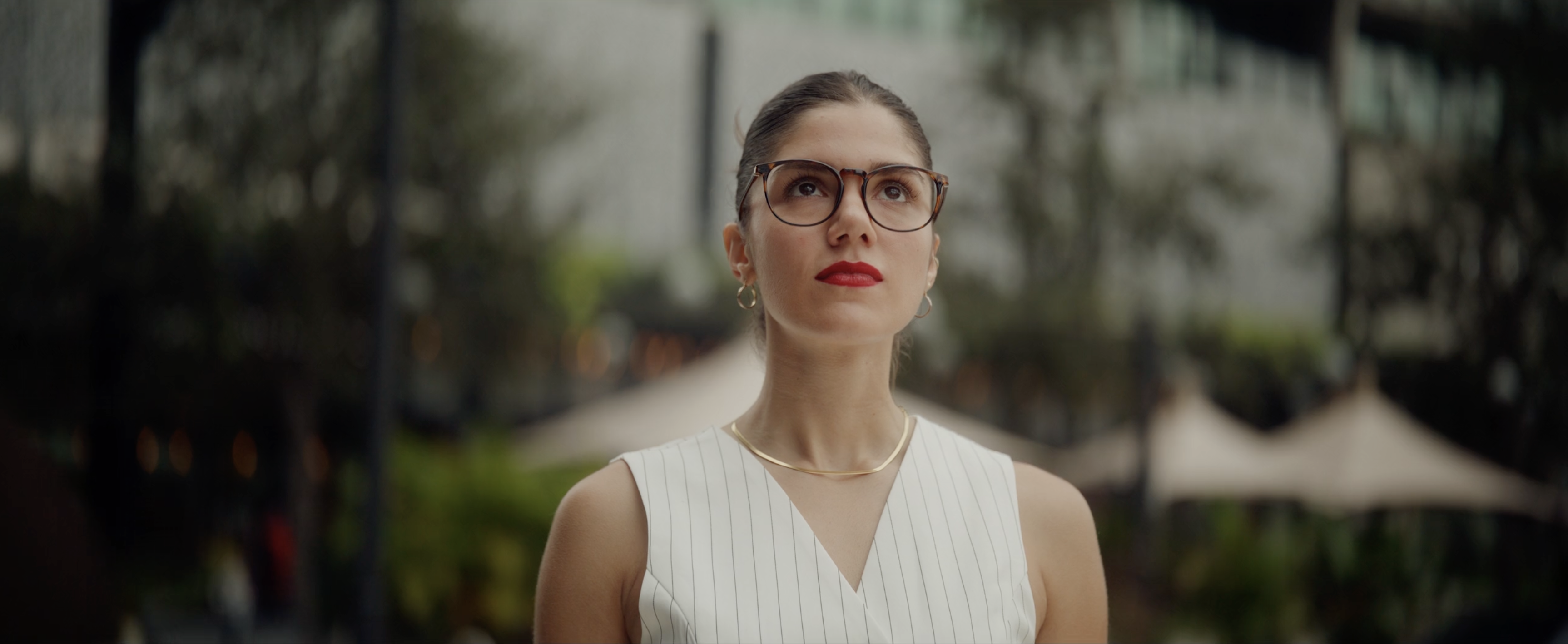 A student standing on campus wearing glasses