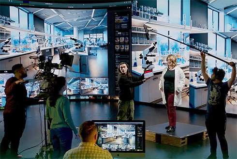 wide angle shot of studio production with actors and camera operators