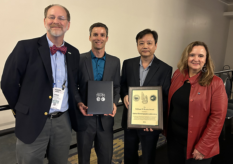 Brian Barnes and Chuanmin Hu (center left and center right) accept the 2024 William T. Pecora Group Award from David Applegate (left), director of the US Geological Survey, and Karen Germain (right), director of NASA’s Earth Science Division. 