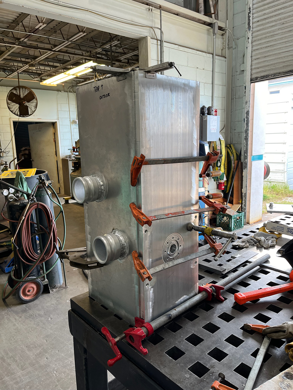 During the initial welding process of the main CUFES box, Miller used clamps to apply pressure in specific directions to prevent the metal from warping as it cooled. This also allowed for small, short welds to make sure the structure was aligned before the final weld. Picture Credit: Garret Miller